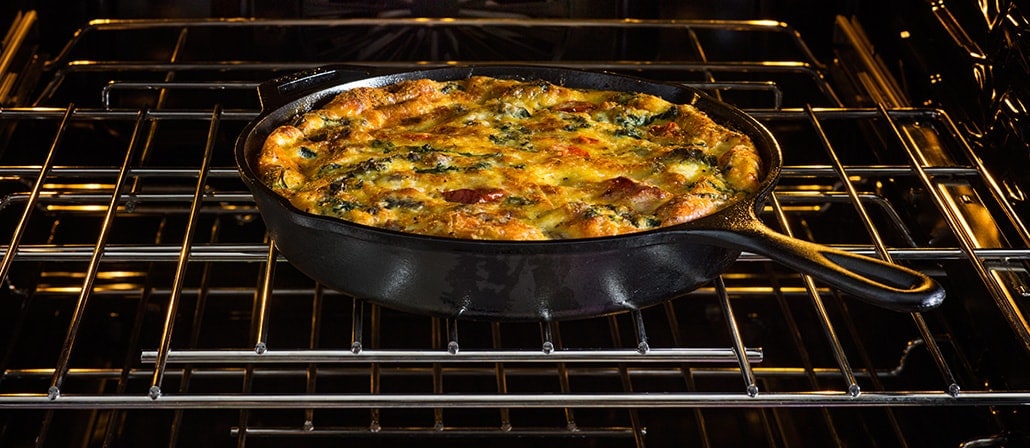 Roasted Tomato, Kale, Goat Cheese and Sausage Frittata in a cast-iron skillet sitting in the oven.  Recipe calls for 9 ingredients, 30 minutes cooking time, 30 minutes prep time, and 8 servings.