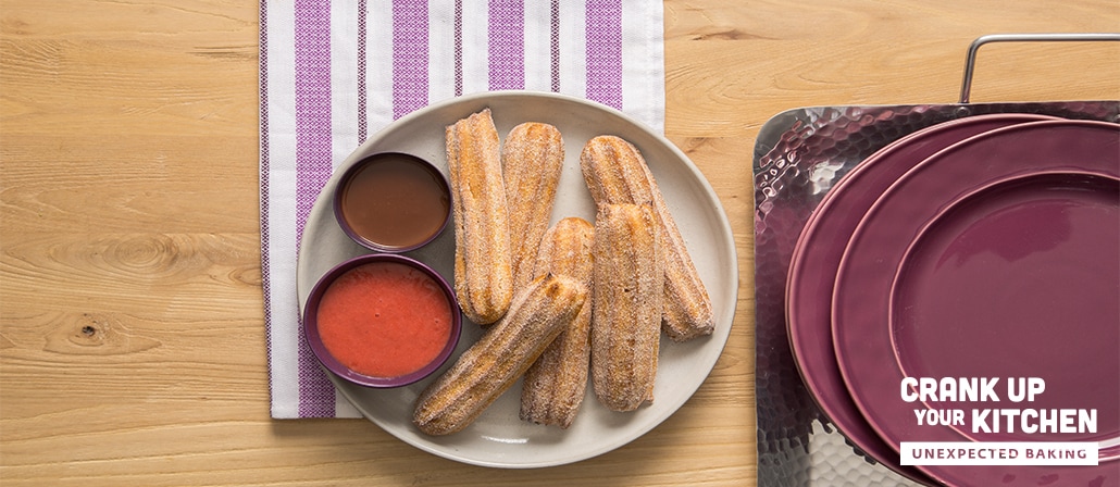 A Plate of cinnamon-covered churros with roasted raspberry dipping sauce and chocolate-peanut butter dipping sauce.  Recipe calls for 16 ingredients, 55 cooking time, 20 minutes prep time, and 9 servings.
