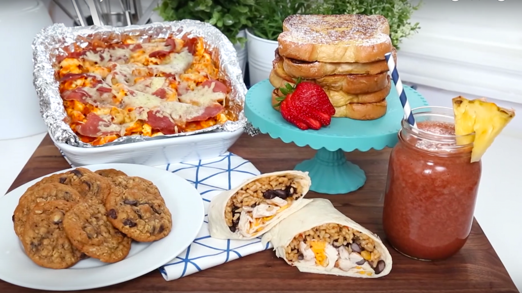 A kitchen table filled with Black bean burrito, Lasagna, French Toast, Pineapple salsa and chocolate chip cookies.