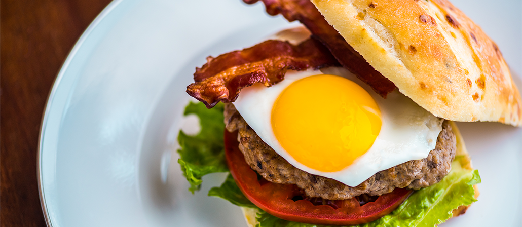 A juicy breakfast burger with fried egg, bacon, tomato, and lettuce on a ciabatta bun.  Recipe calls for 12 ingredients, 60 cooking time, 10 minutes prep time, and 4 servings.