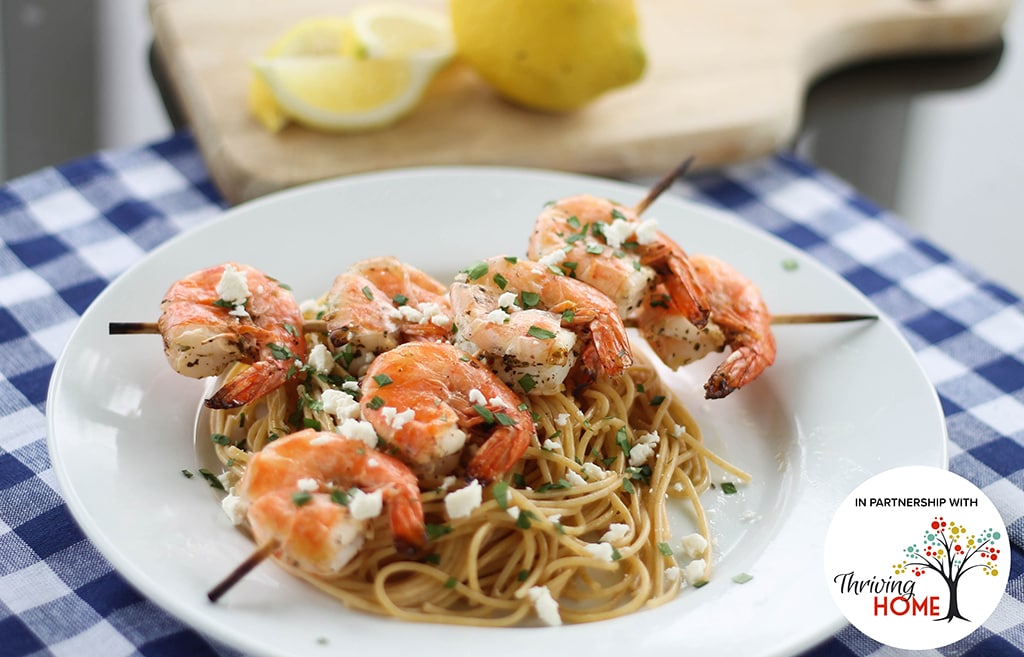 Mediterranean Shrimp on skewers with minced garlic, lemon juice, fresh basil, fresh parsley, and feta cheese crumbles over pasta.  Recipe calls for 12 ingredients, 5 minutes cooking time, 5 minutes prep time, and 4 servings.