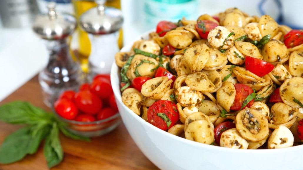 Orecchiette Pasta salad in a bowl with tomatoes, mozzarella balls, and balsamic vinegar.  Recipe calls for 25 ingredients, 50 minutes cooking time, 25 minutes prep time, and 8 servings.