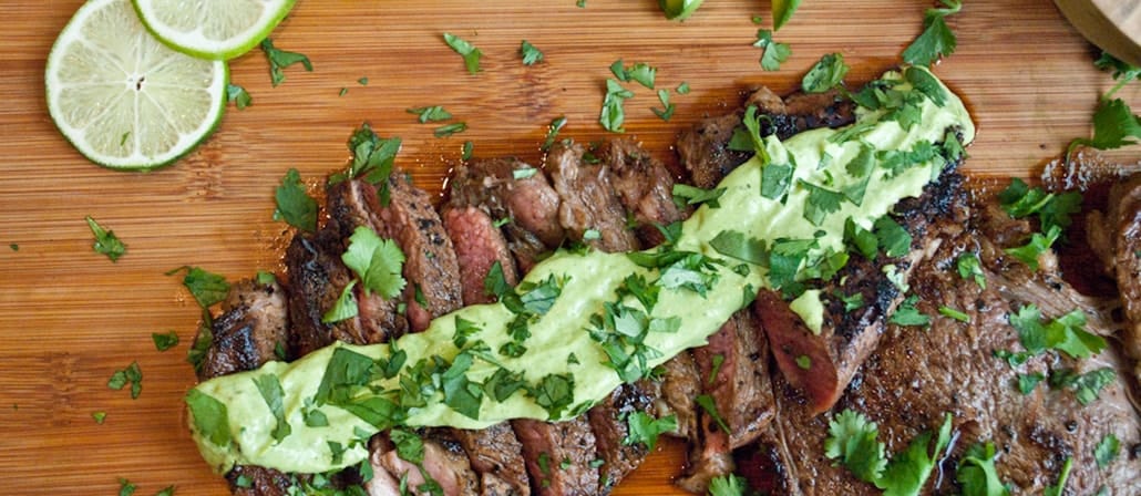 Pan Seared Rib-Eye Steak covered in Wasabi Lime sauce on a wooden cutting board.  Recipe calls for 14 ingredients, 25 minutes cooking time, 8 minutes prep time, and 4 servings.