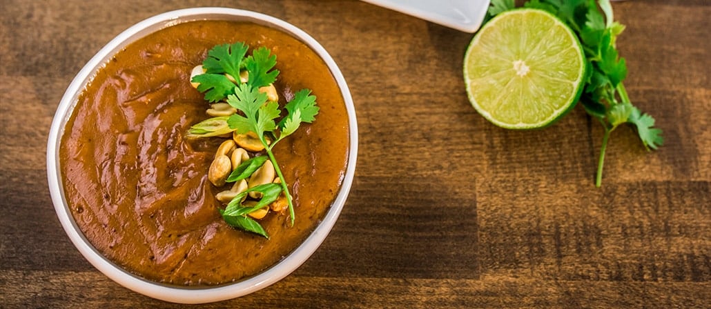 Bowl of Thai peanut sauce garnished with peanuts and cilantro.  Recipe calls for 7 ingredients, 10 minutes cooking time, 5 minutes prep time, and 4 servings.