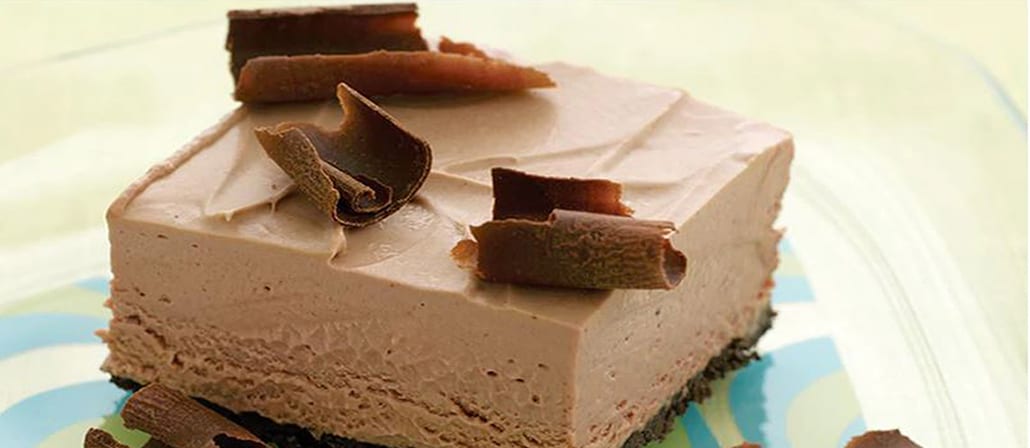 A decadent and rich square piece of chocolate mousse cake with chocolate curls on top.  Recipe calls for 6 ingredients.