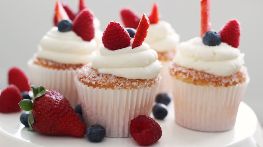 A plate of strawberries, blueberries, raspberries, and delicious cupcakes topped with cream cheese.  Recipe calls for 9 ingredients, 45 cooking time, 15 minutes prep time, and 24 servings.
